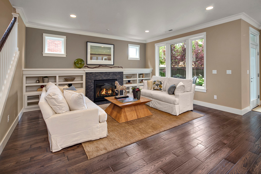 Example of a classic open concept medium tone wood floor living room design in Seattle with multicolored walls, a standard fireplace, a tile fireplace and a wall-mounted tv
