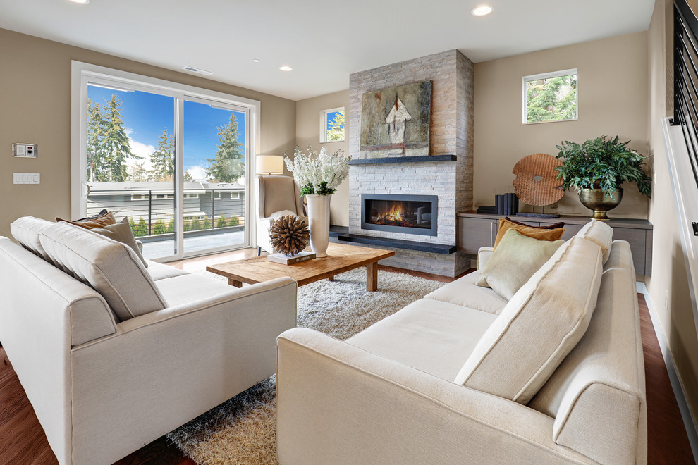 Inspiration for a contemporary formal open plan living room in Seattle with beige walls, light hardwood flooring, a standard fireplace, a wall mounted tv and a tiled fireplace surround.