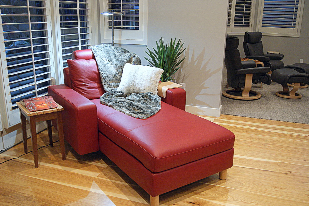 Immagine di un soggiorno minimal aperto con pareti grigie, pavimento in legno massello medio, camino bifacciale e cornice del camino piastrellata