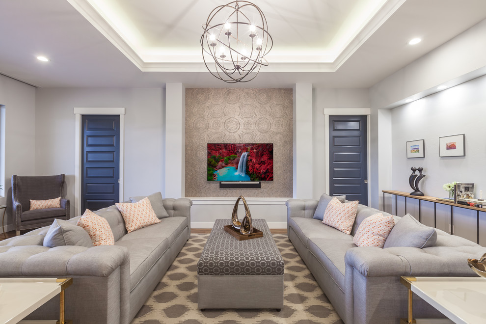 Modelo de salón para visitas abierto contemporáneo de tamaño medio sin chimenea con paredes azules, suelo de madera en tonos medios, suelo marrón y televisor colgado en la pared