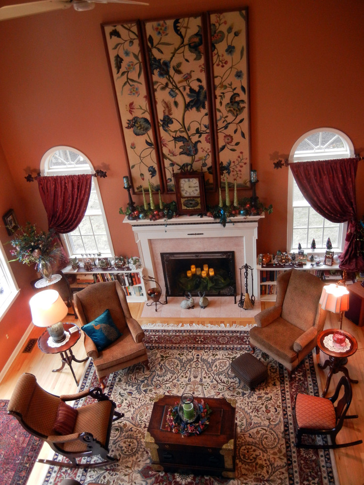 Пример оригинального дизайна: большая открытая гостиная комната в классическом стиле с оранжевыми стенами, паркетным полом среднего тона, стандартным камином и фасадом камина из камня без телевизора