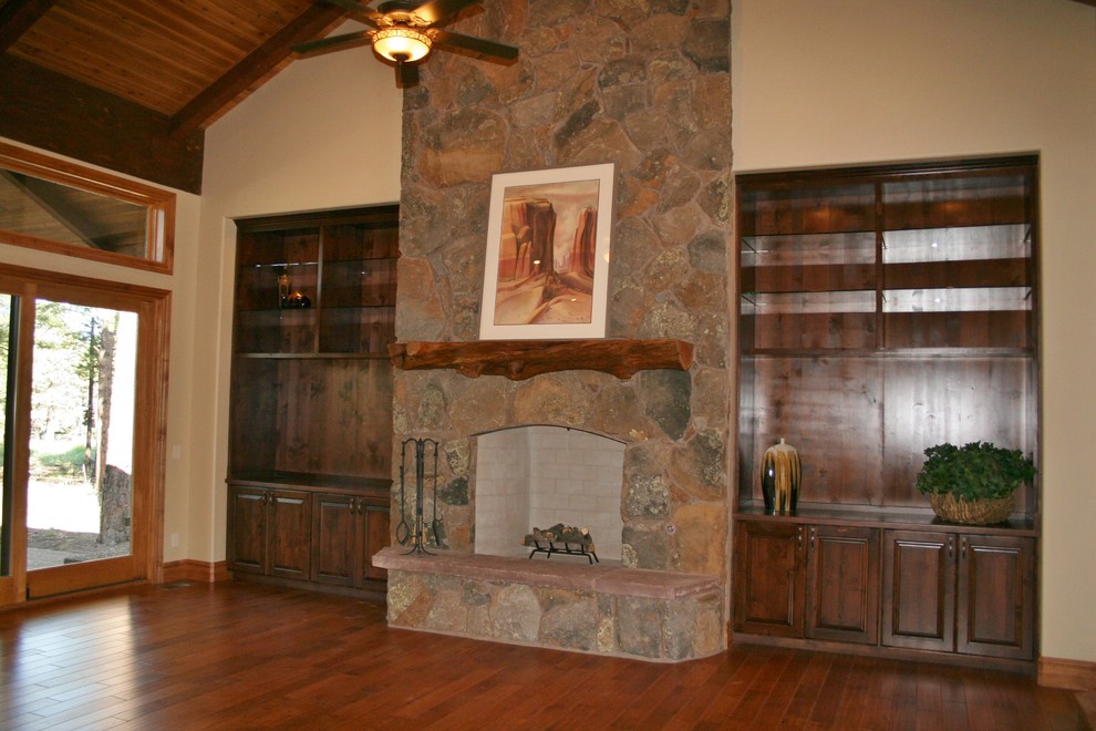 Imagen de salón rústico con todas las chimeneas, marco de chimenea de piedra y pared multimedia
