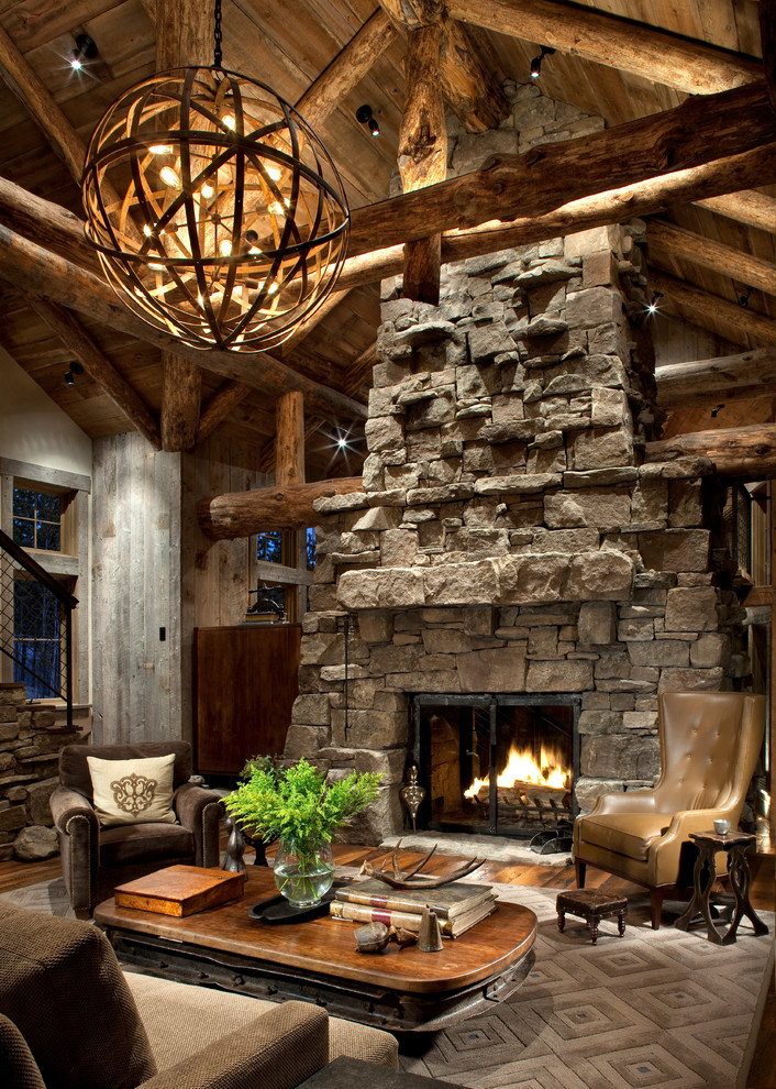Living room - rustic medium tone wood floor living room idea in Other with a stone fireplace and a standard fireplace