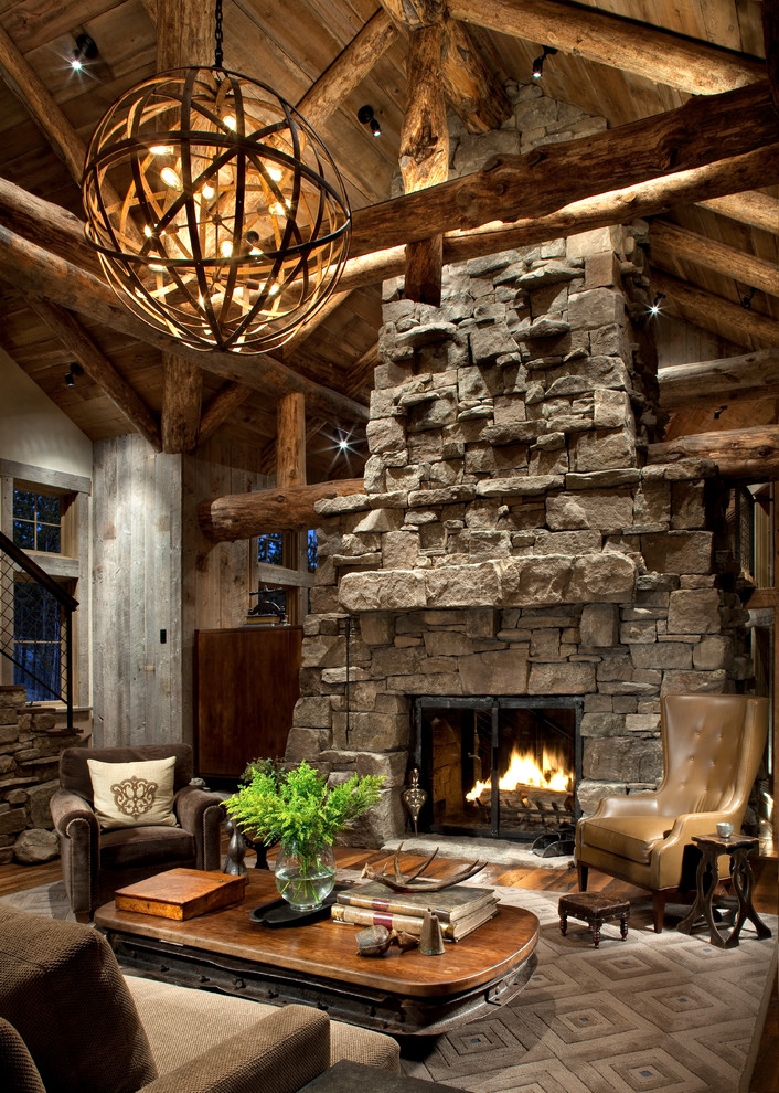 Idées déco pour un salon montagne avec un manteau de cheminée en pierre, un sol en bois brun et une cheminée standard.