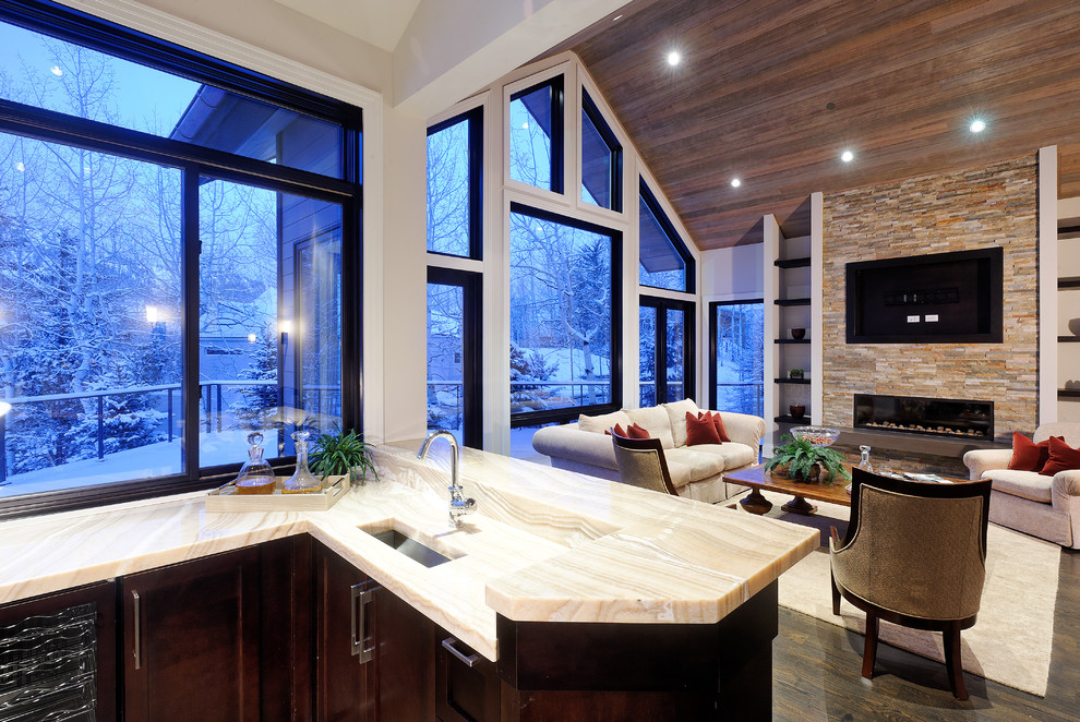 Стильный дизайн: гостиная комната в стиле рустика с фасадом камина из камня и ковром на полу - последний тренд
