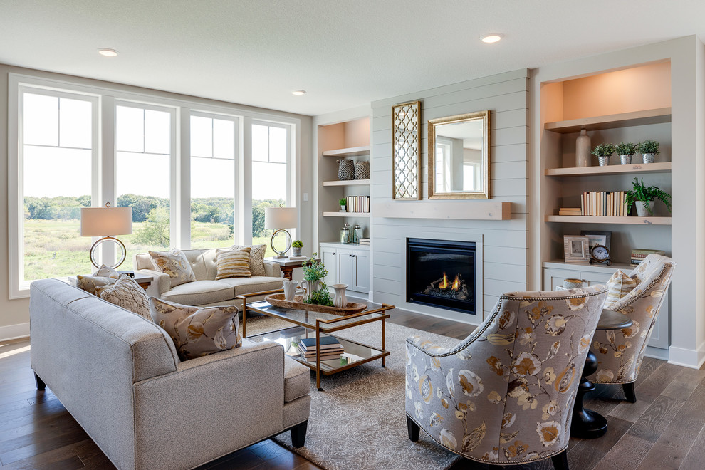 Fernseherloses Landhausstil Wohnzimmer mit grauer Wandfarbe, braunem Holzboden und Kamin in Minneapolis