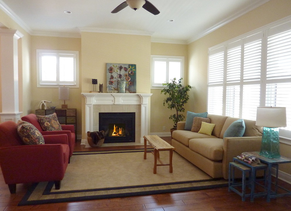 Cette photo montre un salon tendance de taille moyenne et ouvert avec un mur beige, parquet foncé, une cheminée standard, un manteau de cheminée en carrelage et un sol marron.
