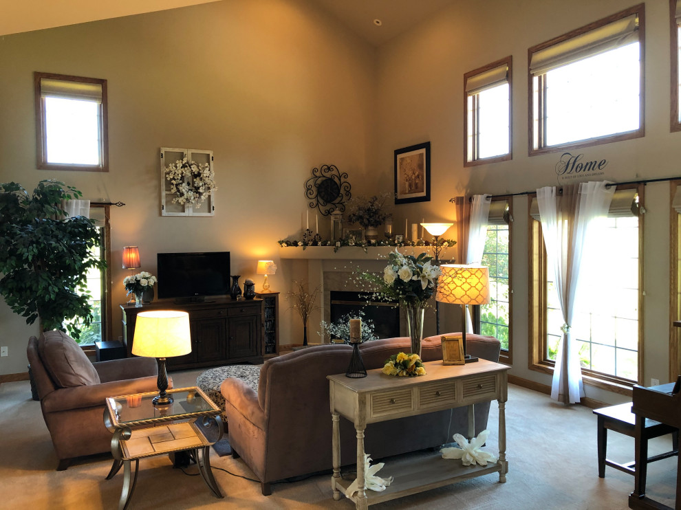This is an example of a large classic open plan living room in Milwaukee with beige walls, carpet, a corner fireplace, a tiled fireplace surround, a freestanding tv and beige floors.
