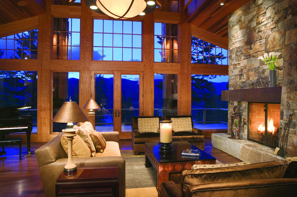 Стильный дизайн: гостиная комната в стиле рустика с фасадом камина из камня - последний тренд