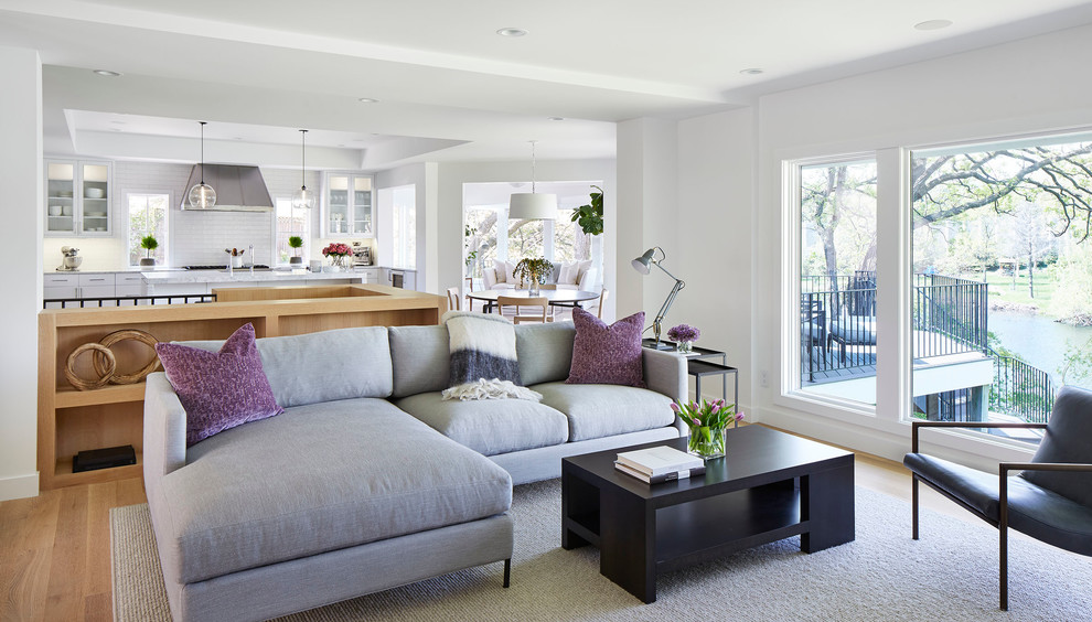 Mid-sized trendy open concept light wood floor and beige floor living room photo in Minneapolis with white walls, a wall-mounted tv, a two-sided fireplace and a plaster fireplace