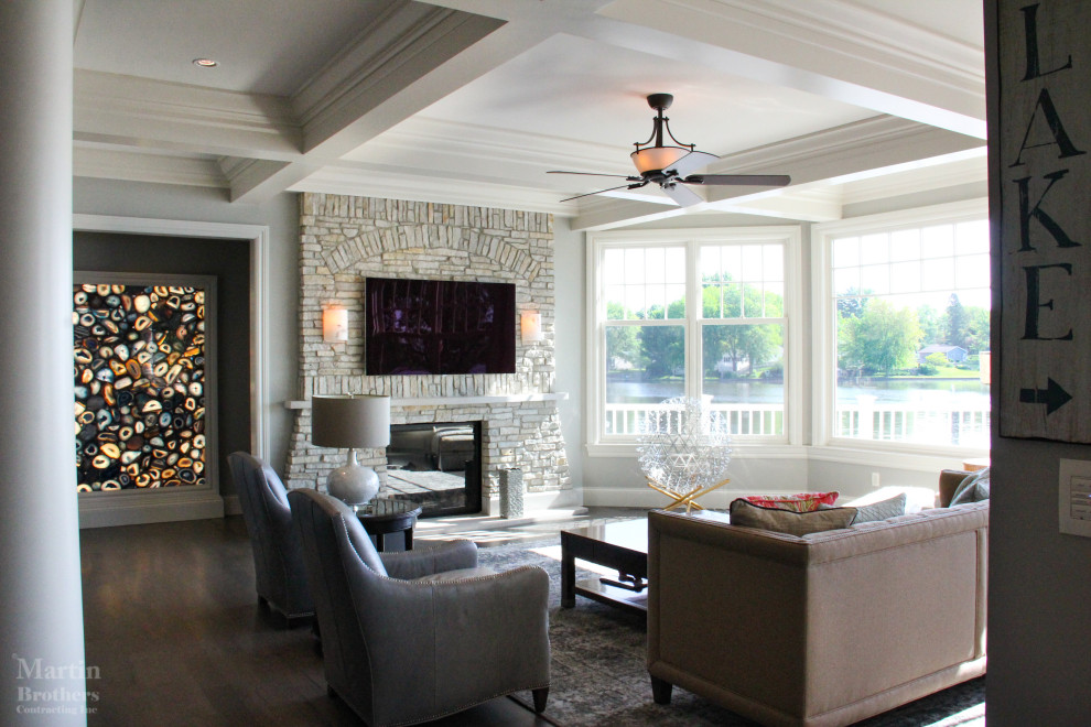 Design ideas for an expansive classic open plan living room in Other with grey walls, light hardwood flooring, a standard fireplace, a stacked stone fireplace surround and a wall mounted tv.