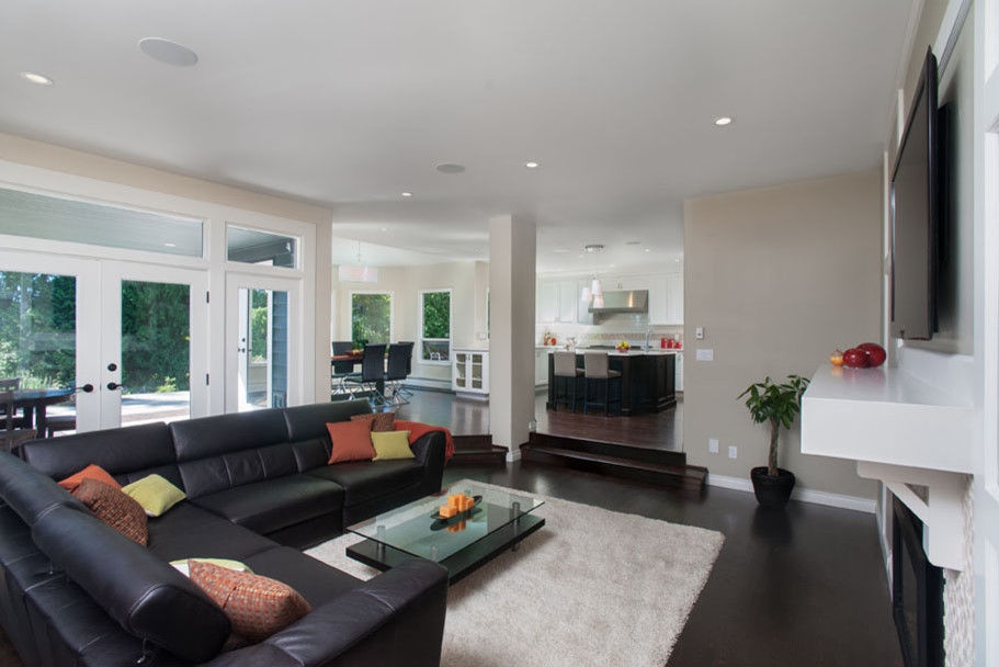 Foto di un grande soggiorno minimal aperto con pareti beige, parquet scuro, camino classico e TV a parete
