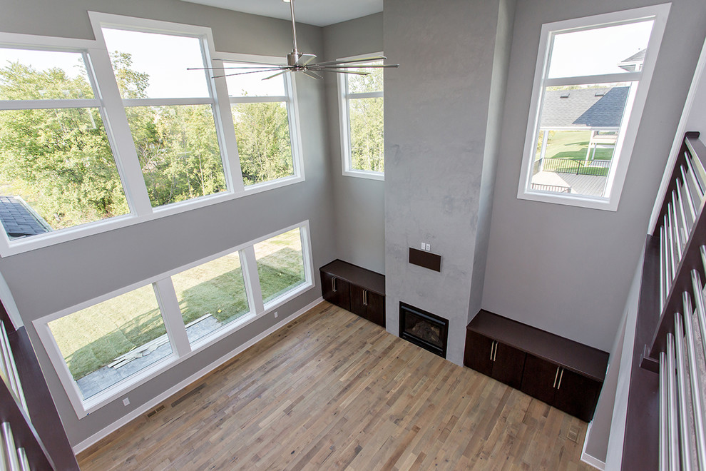 Foto di un grande soggiorno contemporaneo aperto con pareti grigie, pavimento in legno massello medio e pavimento beige