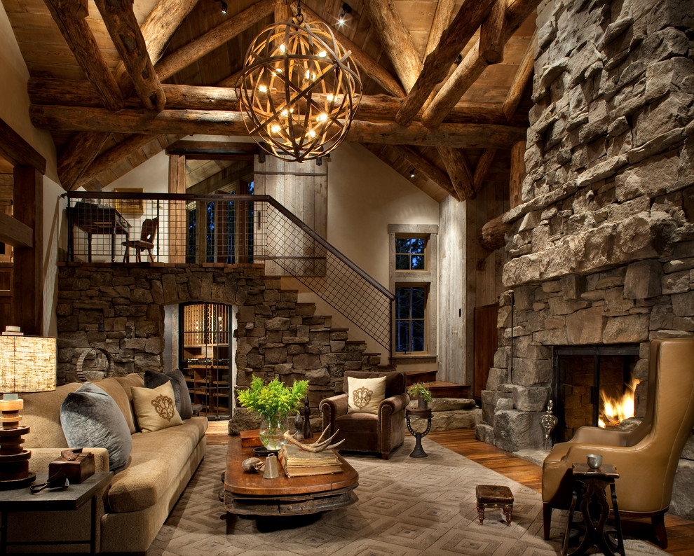 Exemple d'un salon montagne avec un manteau de cheminée en pierre, un sol en bois brun, une cheminée standard, éclairage et un mur en pierre.