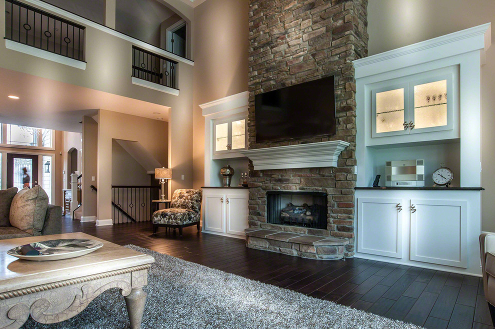 Large contemporary open plan living room in Cleveland with beige walls, dark hardwood flooring, a standard fireplace, a stone fireplace surround and a wall mounted tv.