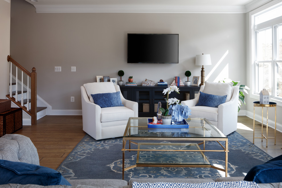 Foto di un soggiorno chic di medie dimensioni con pareti grigie, pavimento in laminato, TV a parete e pavimento marrone