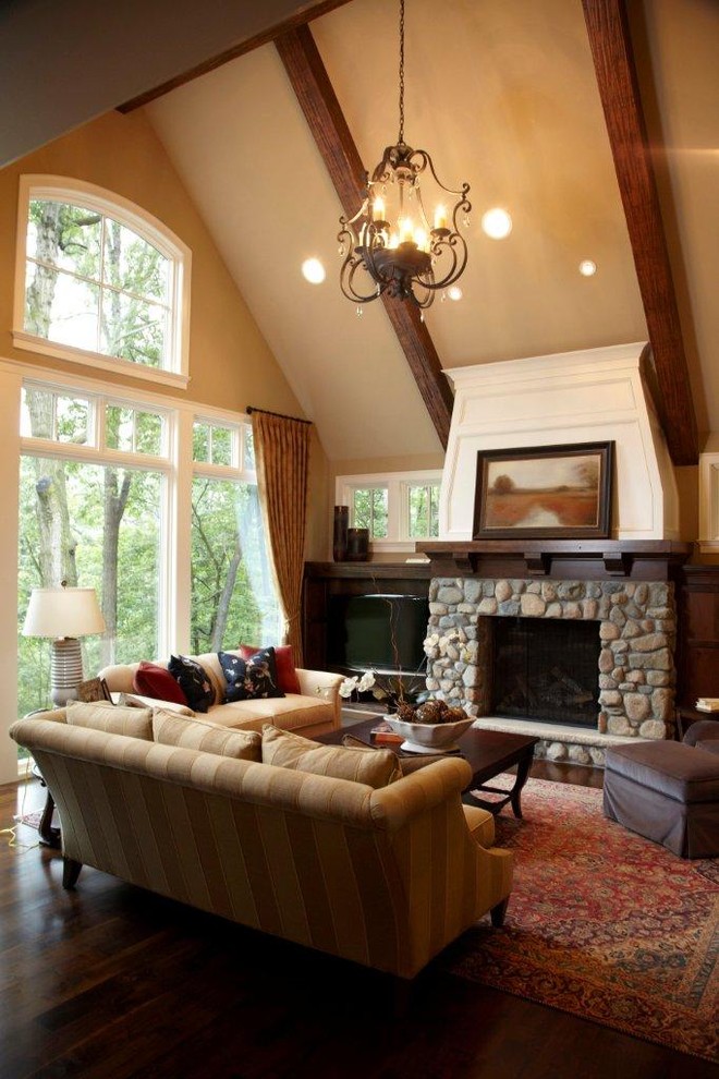 Идея дизайна: гостиная комната в классическом стиле с фасадом камина из камня и ковром на полу