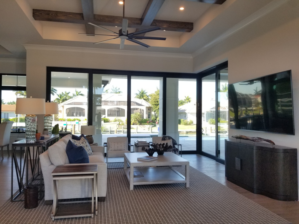 Large classic formal open plan living room in Miami with beige walls, medium hardwood flooring, a wall mounted tv and beige floors.