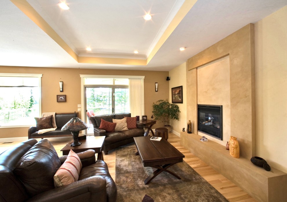 Small transitional formal and open concept light wood floor living room photo in Vancouver with beige walls, a standard fireplace and a plaster fireplace
