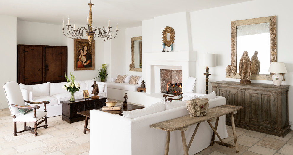На фото: большая парадная, изолированная гостиная комната в средиземноморском стиле с белыми стенами, полом из известняка, стандартным камином и фасадом камина из штукатурки без телевизора