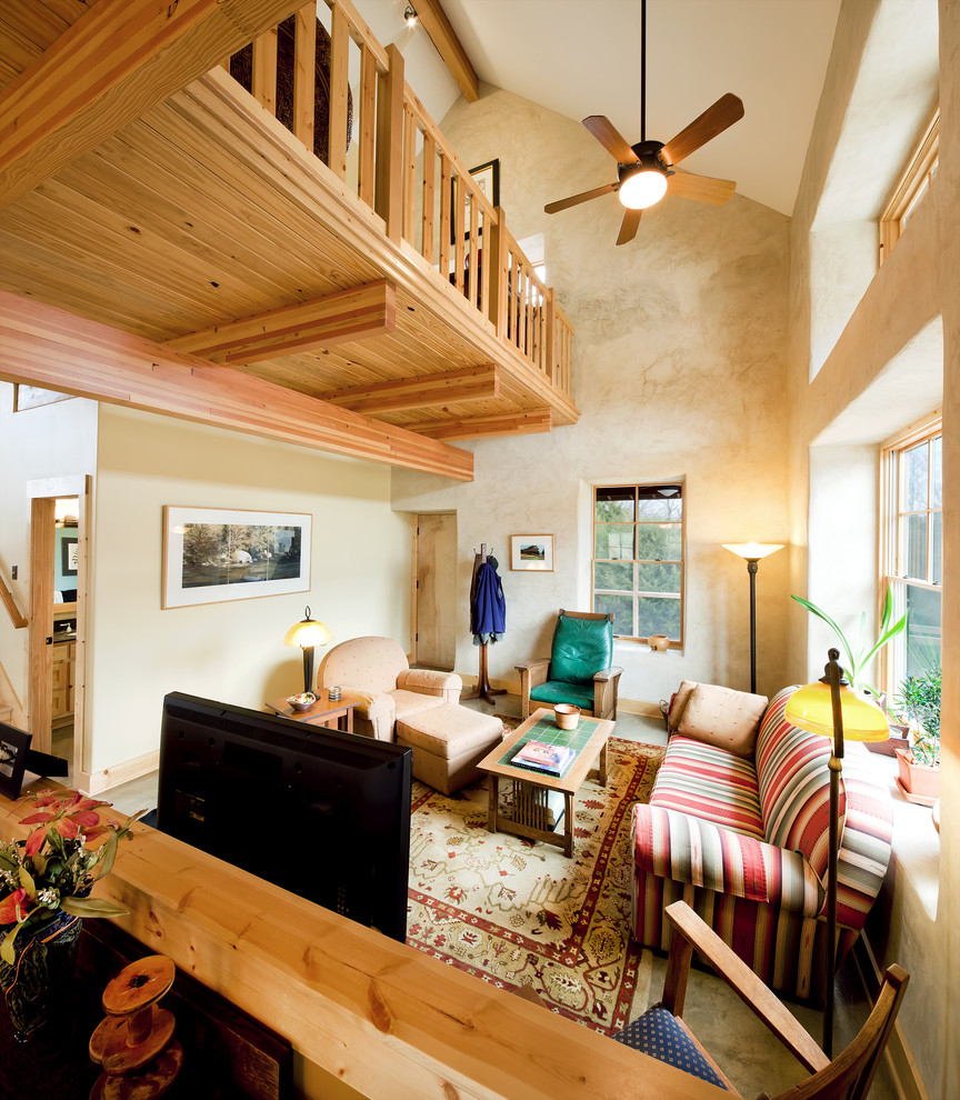 Kleines Rustikales Wohnzimmer ohne Kamin, im Loft-Stil mit beiger Wandfarbe, Betonboden und freistehendem TV in Kansas City