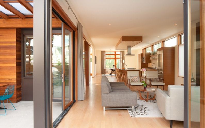 Immagine di un soggiorno minimalista di medie dimensioni e aperto con pareti beige, TV a parete e pavimento beige