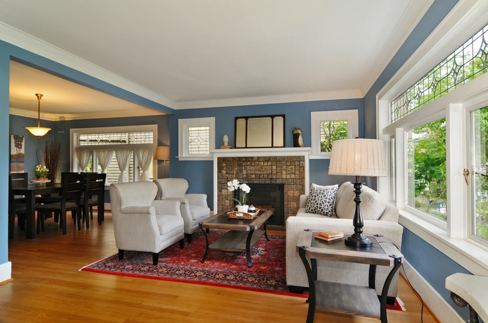 Diseño de salón de estilo americano con paredes azules y marco de chimenea de baldosas y/o azulejos