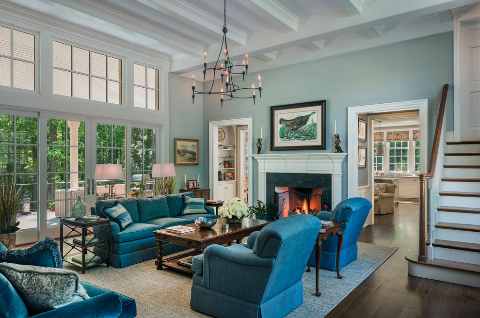 Источник вдохновения для домашнего уюта: большая открытая гостиная комната в классическом стиле с синими стенами, стандартным камином, фасадом камина из дерева и паркетным полом среднего тона без телевизора