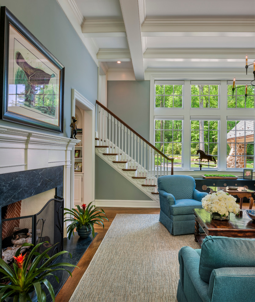 Стильный дизайн: большая открытая гостиная комната в классическом стиле с синими стенами, паркетным полом среднего тона, стандартным камином и фасадом камина из дерева без телевизора - последний тренд