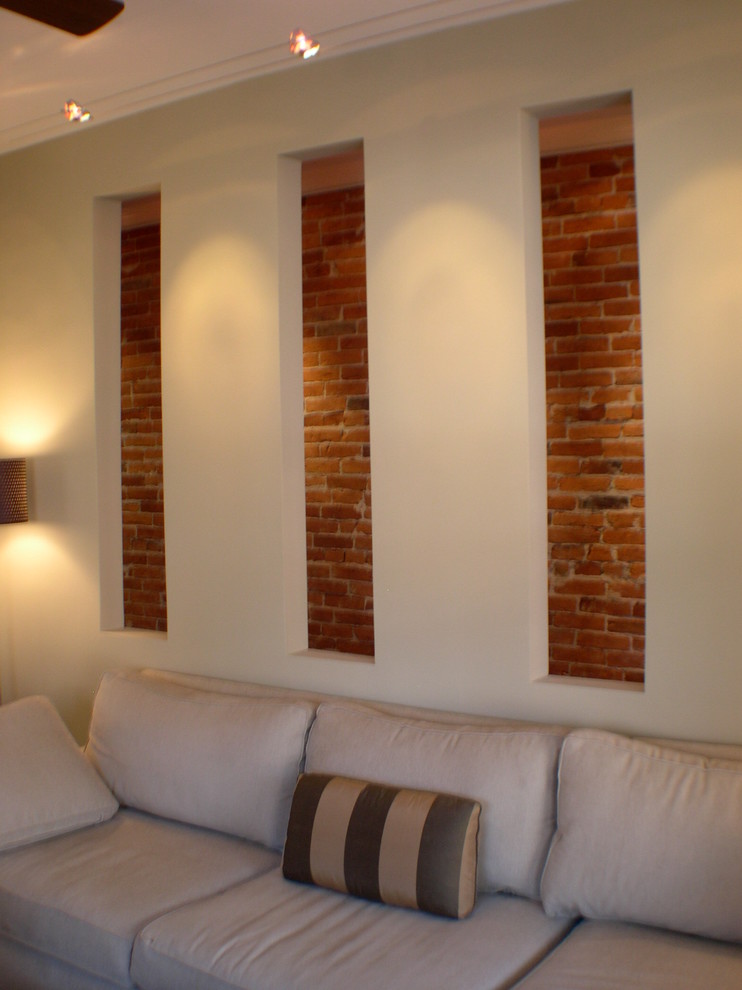 Modelo de salón actual con paredes beige y suelo de madera en tonos medios