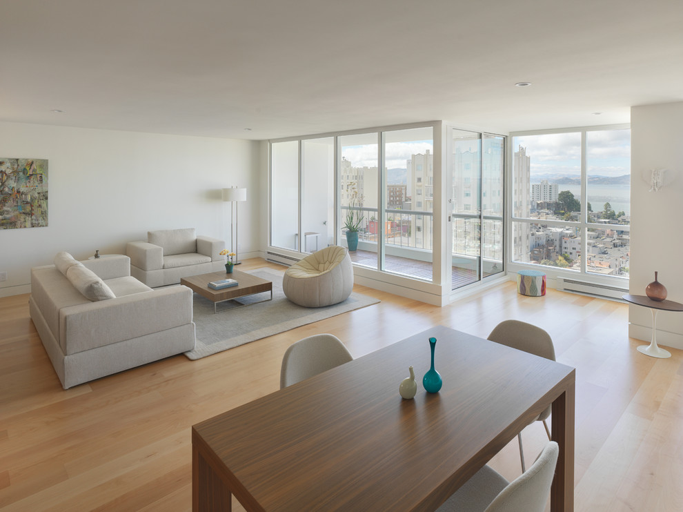Imagen de salón para visitas abierto moderno de tamaño medio sin chimenea y televisor con paredes blancas, suelo de madera clara y suelo marrón