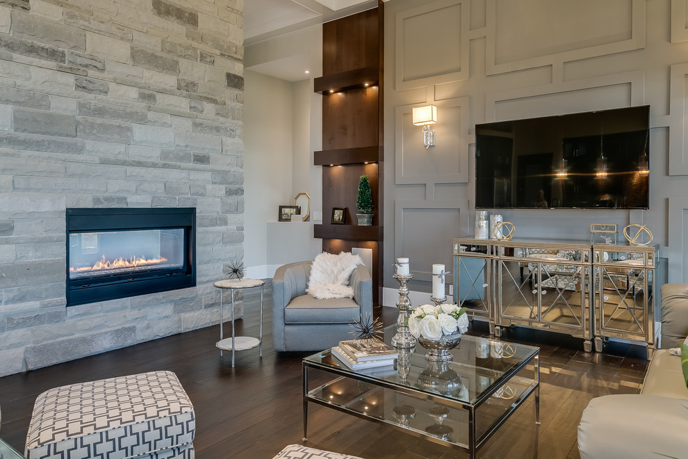 Идея дизайна: открытая гостиная комната в стиле неоклассика (современная классика) с серыми стенами, темным паркетным полом, горизонтальным камином, фасадом камина из камня и телевизором на стене