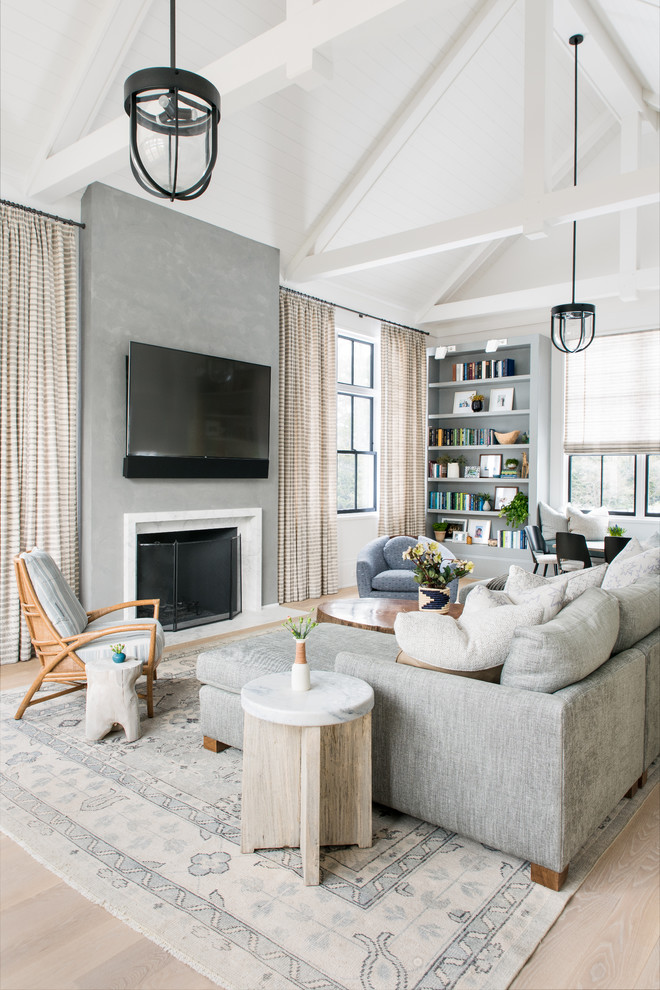 Foto de salón de estilo de casa de campo con paredes blancas, suelo de madera clara, todas las chimeneas, televisor colgado en la pared y suelo beige