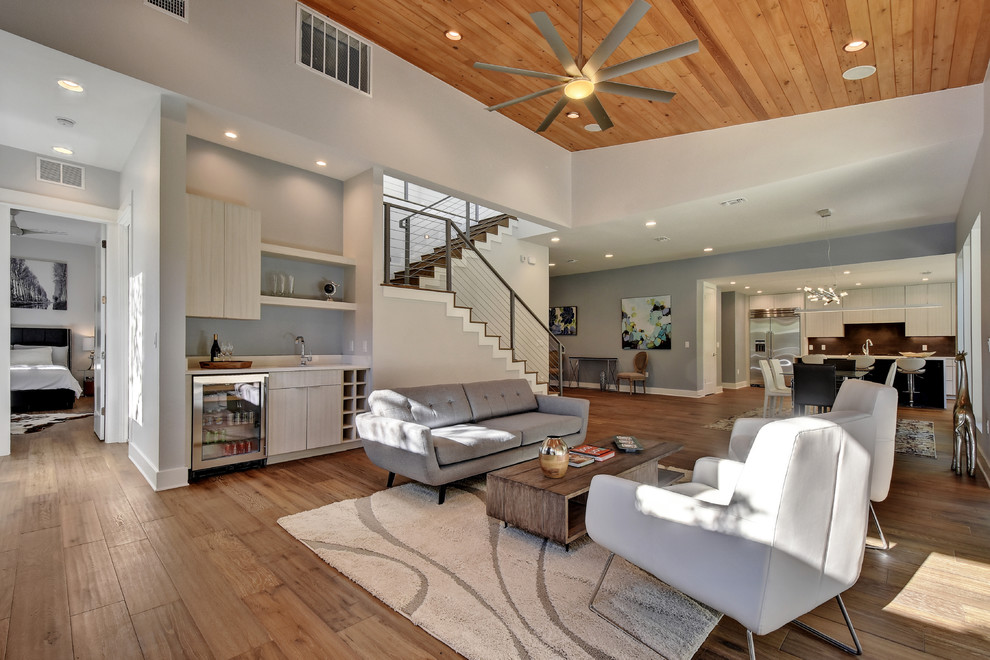 Design ideas for a medium sized contemporary open plan living room in Austin with a home bar, grey walls, dark hardwood flooring, a ribbon fireplace, a stone fireplace surround, a built-in media unit and brown floors.