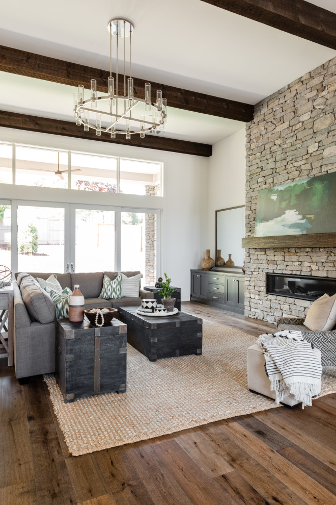 Geräumiges Mediterranes Wohnzimmer mit weißer Wandfarbe, braunem Holzboden, Gaskamin, Kaminumrandung aus Stein und braunem Boden in Sacramento