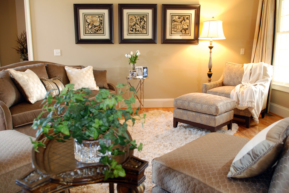 Immagine di un soggiorno tradizionale di medie dimensioni e chiuso con pareti beige, parquet chiaro e camino classico