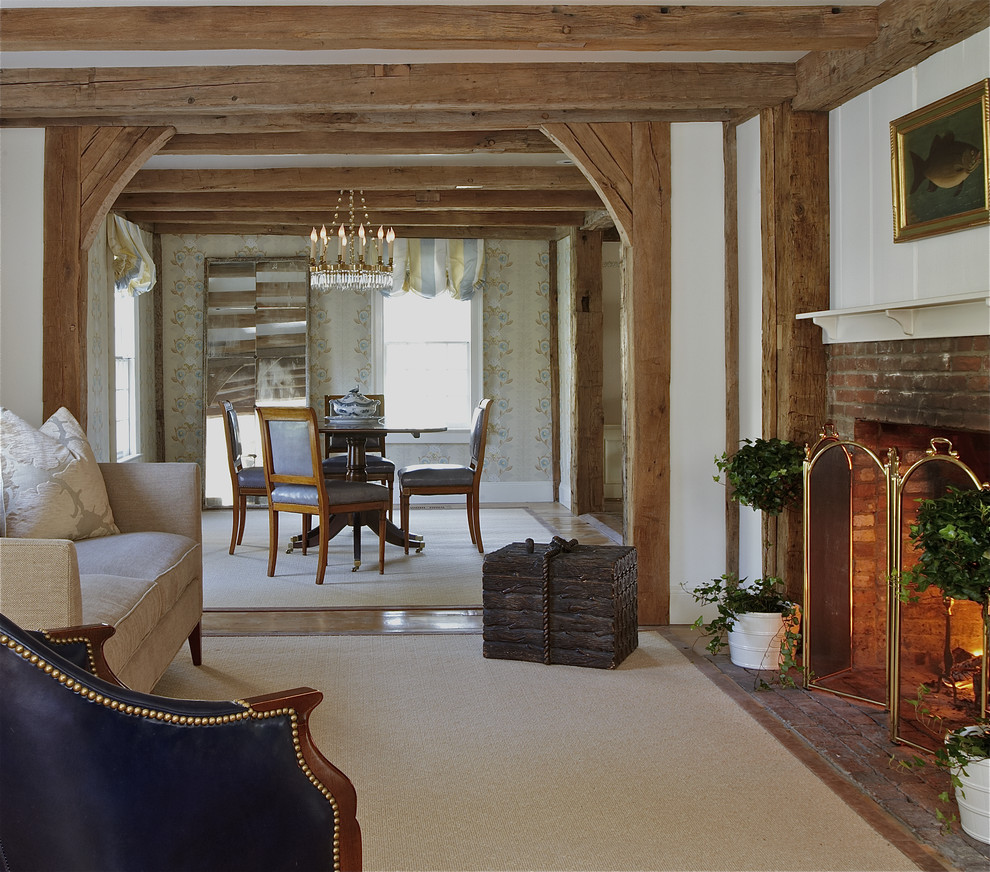 Modelo de salón abierto de estilo de casa de campo con paredes blancas, suelo de madera clara, todas las chimeneas y marco de chimenea de ladrillo