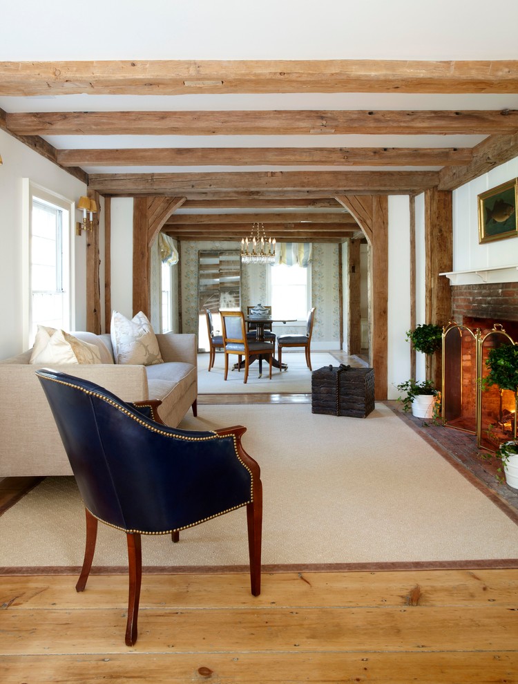 Offenes Landhaus Wohnzimmer mit weißer Wandfarbe, hellem Holzboden, Kamin und Kaminumrandung aus Backstein in New York