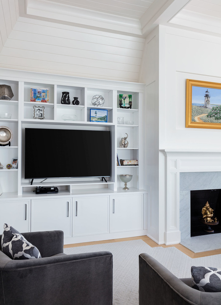 Cette image montre un salon traditionnel de taille moyenne et fermé avec une salle de réception, un mur blanc, parquet clair, une cheminée standard, un manteau de cheminée en pierre, un téléviseur encastré et un sol marron.