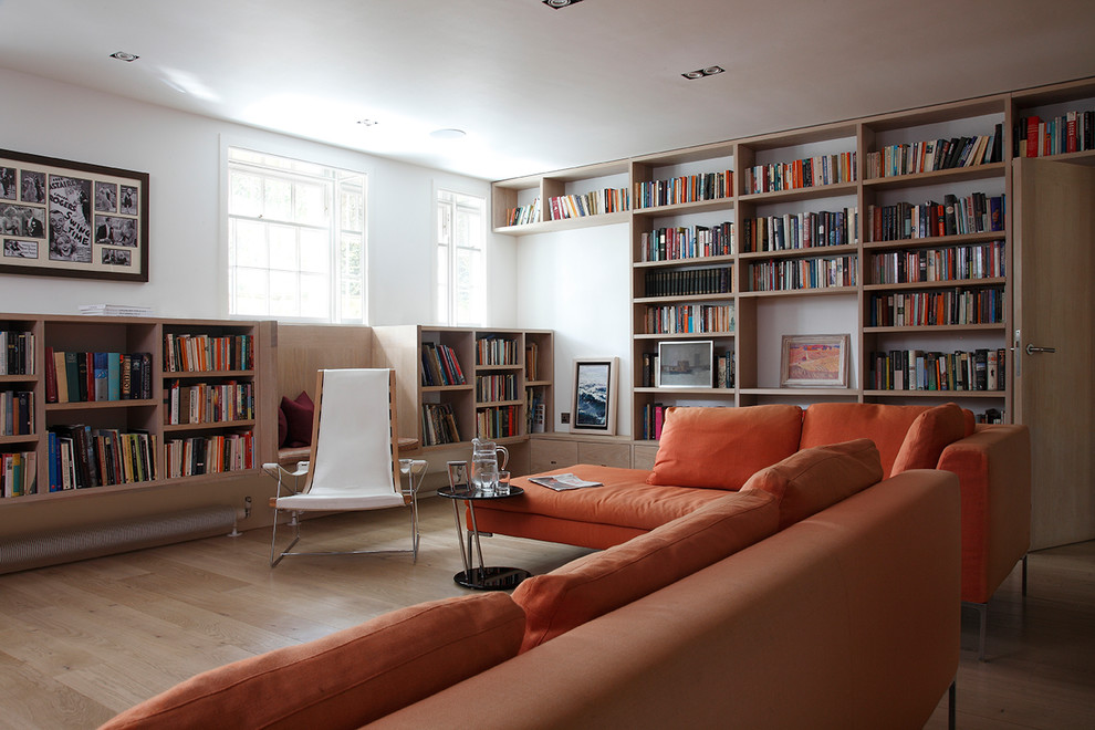This is an example of a medium sized contemporary enclosed living room in London with white walls and beige floors.