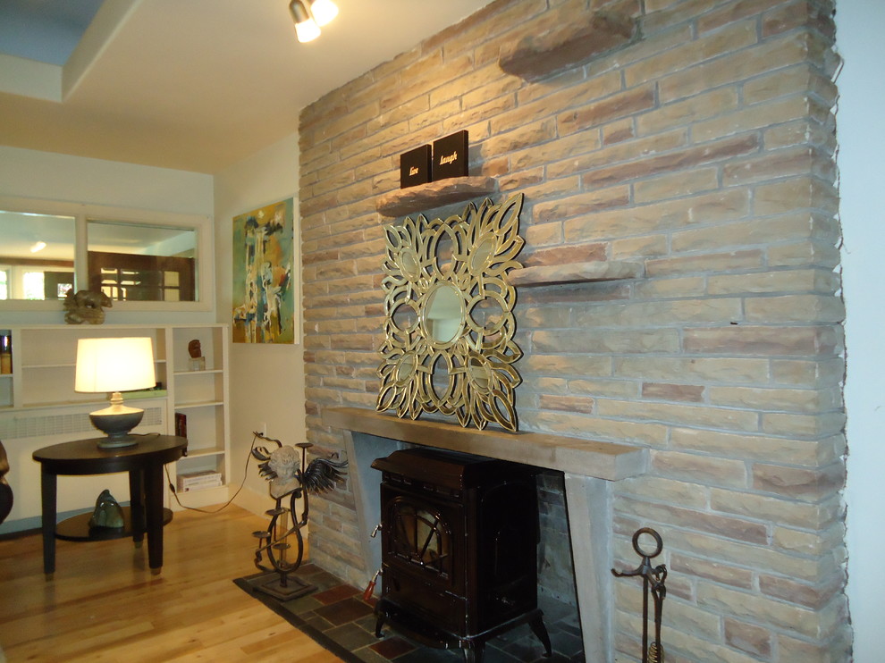 Foto de salón abierto contemporáneo extra grande con paredes beige, suelo de madera clara y marco de chimenea de ladrillo