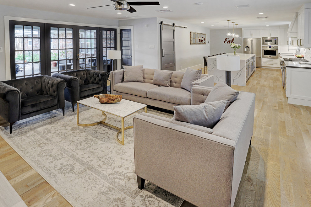 Mittelgroßes, Abgetrenntes Klassisches Wohnzimmer mit grauer Wandfarbe, hellem Holzboden, Kamin, Kaminumrandung aus Holz, TV-Wand und gelbem Boden in Houston