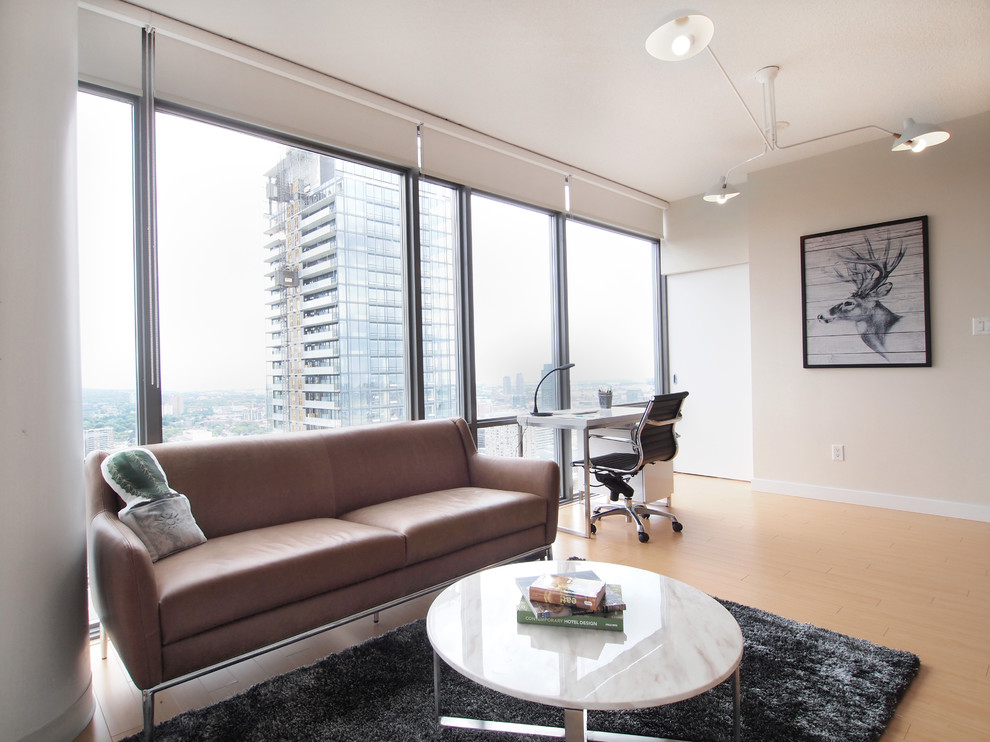 Immagine di un piccolo soggiorno moderno aperto con pareti bianche e pavimento in laminato