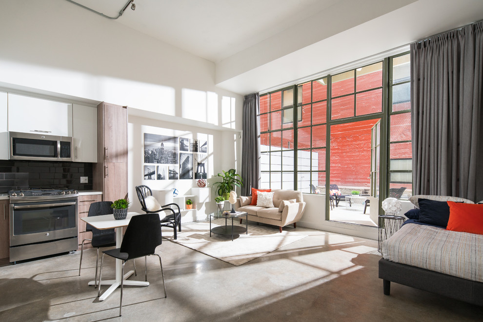 Offenes Industrial Wohnzimmer mit weißer Wandfarbe, Betonboden und grauem Boden in Los Angeles