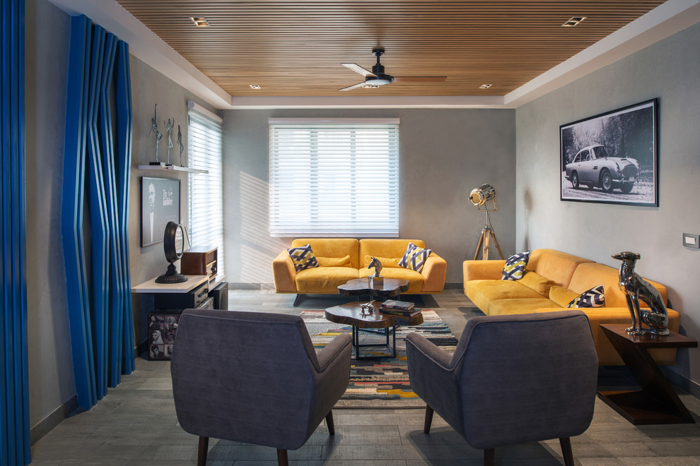 This is an example of a retro formal and grey and yellow enclosed living room in Delhi with grey walls, no tv and grey floors.