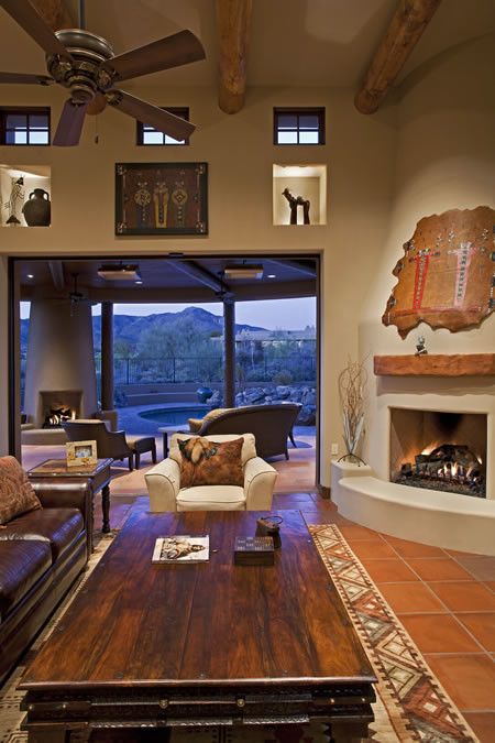 Großes, Repräsentatives, Offenes Mediterranes Wohnzimmer mit beiger Wandfarbe, Eckkamin, verputzter Kaminumrandung, Terrakottaboden und TV-Wand in Phoenix