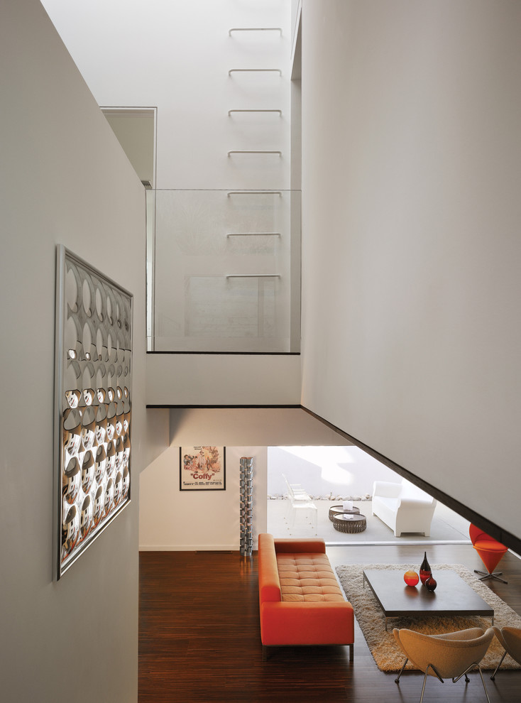 Immagine di un piccolo soggiorno moderno aperto con pareti bianche, parquet scuro e tappeto