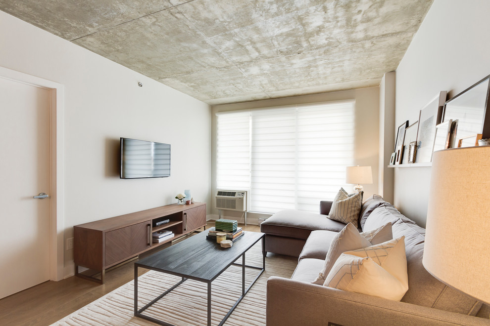 Ispirazione per un piccolo soggiorno design stile loft con pareti bianche, parquet chiaro e TV a parete