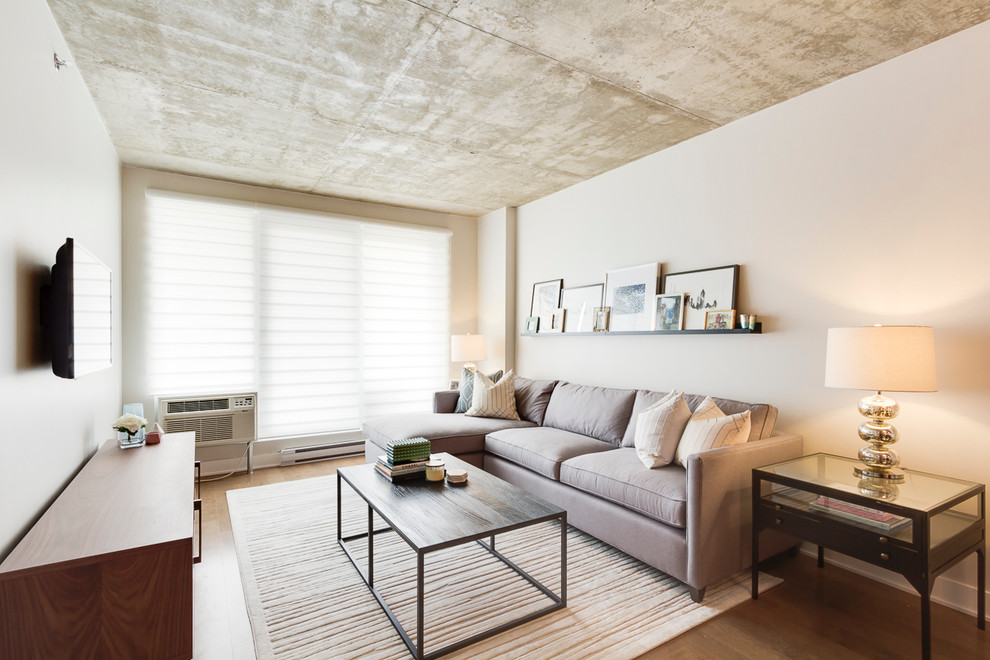 Foto de salón tipo loft contemporáneo pequeño con paredes blancas, suelo de madera clara y televisor colgado en la pared