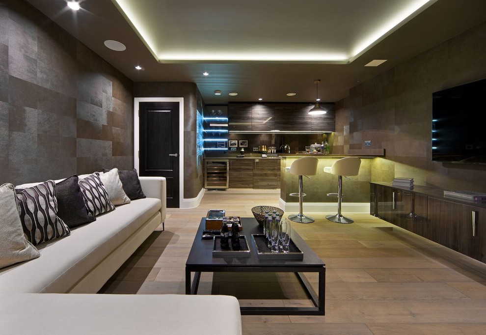 Пример оригинального дизайна: большая открытая гостиная комната в современном стиле с серыми стенами, светлым паркетным полом и телевизором на стене